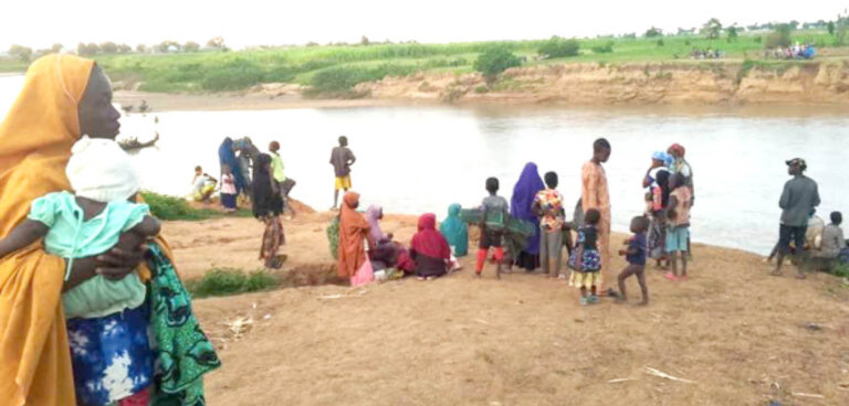 Some-of-the-fleeing-community-members-waiting-to-cross-a-river-in-the-area